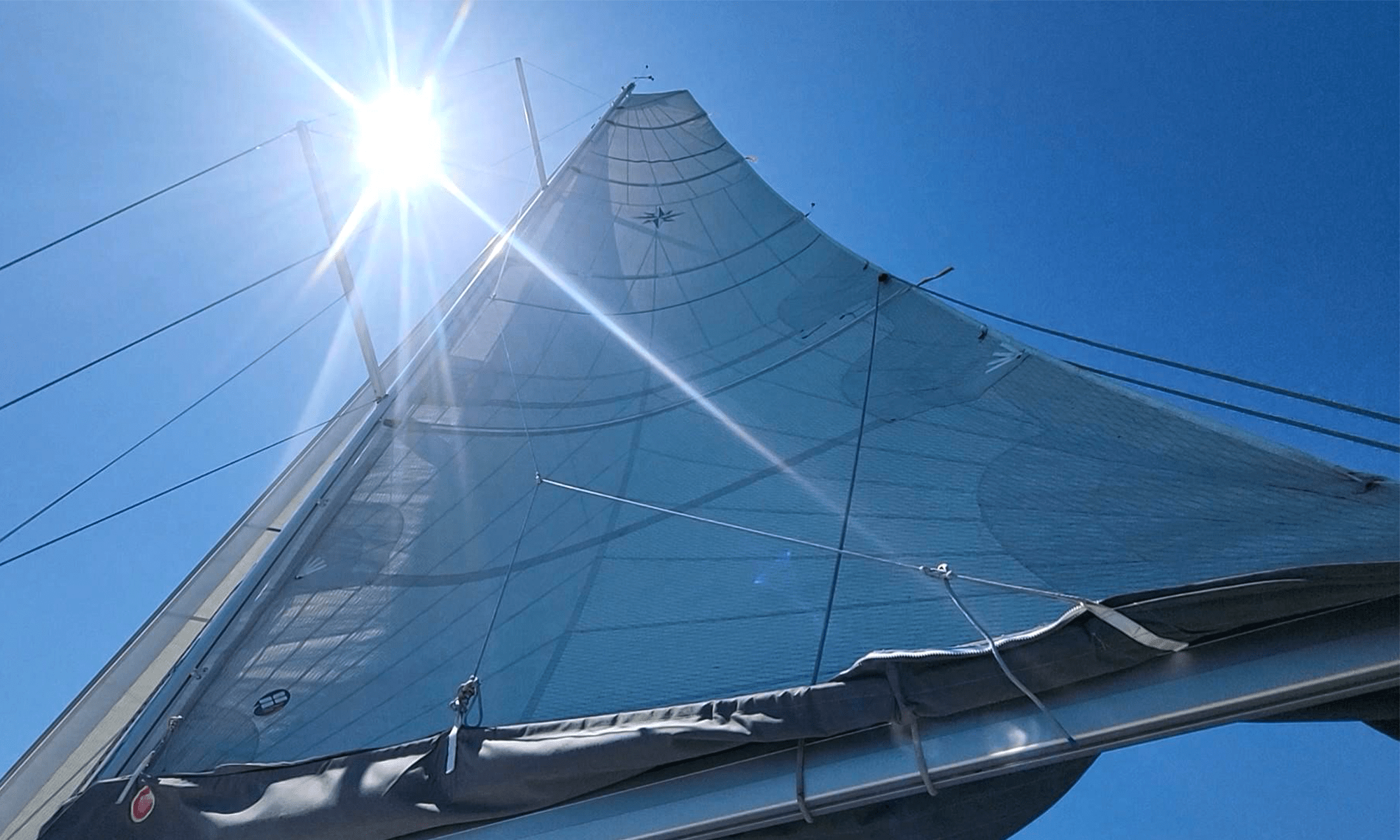 The mainsail hoisted high on the mast of a sailboat