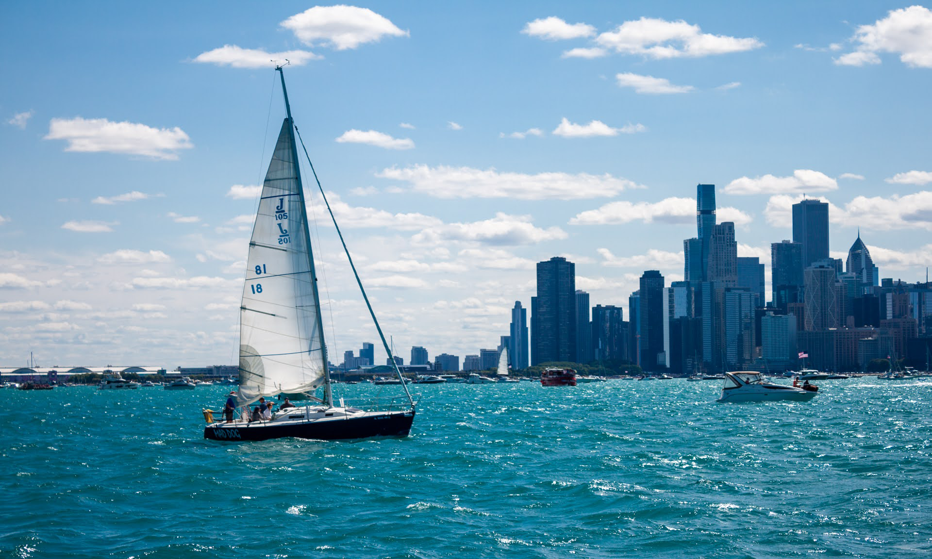 sailboat on water with skyline in background