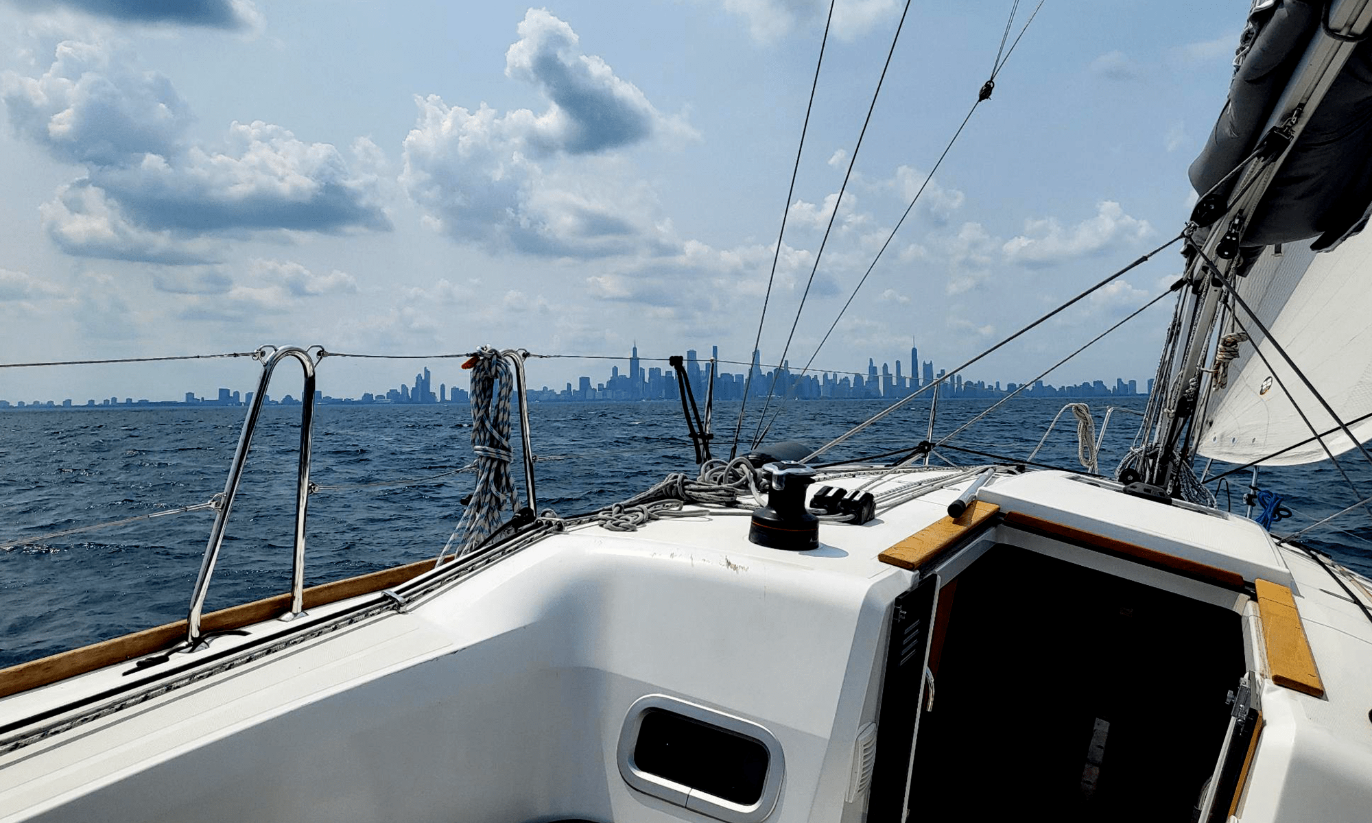 The Chicago skyline seen from Lake Michigan in the background, with a sailboat in the foreground