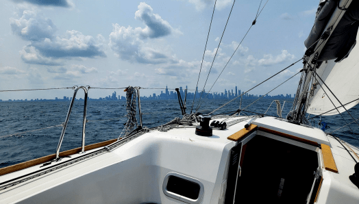 The Chicago skyline seen from Lake Michigan in the background, with a sailboat in the foreground