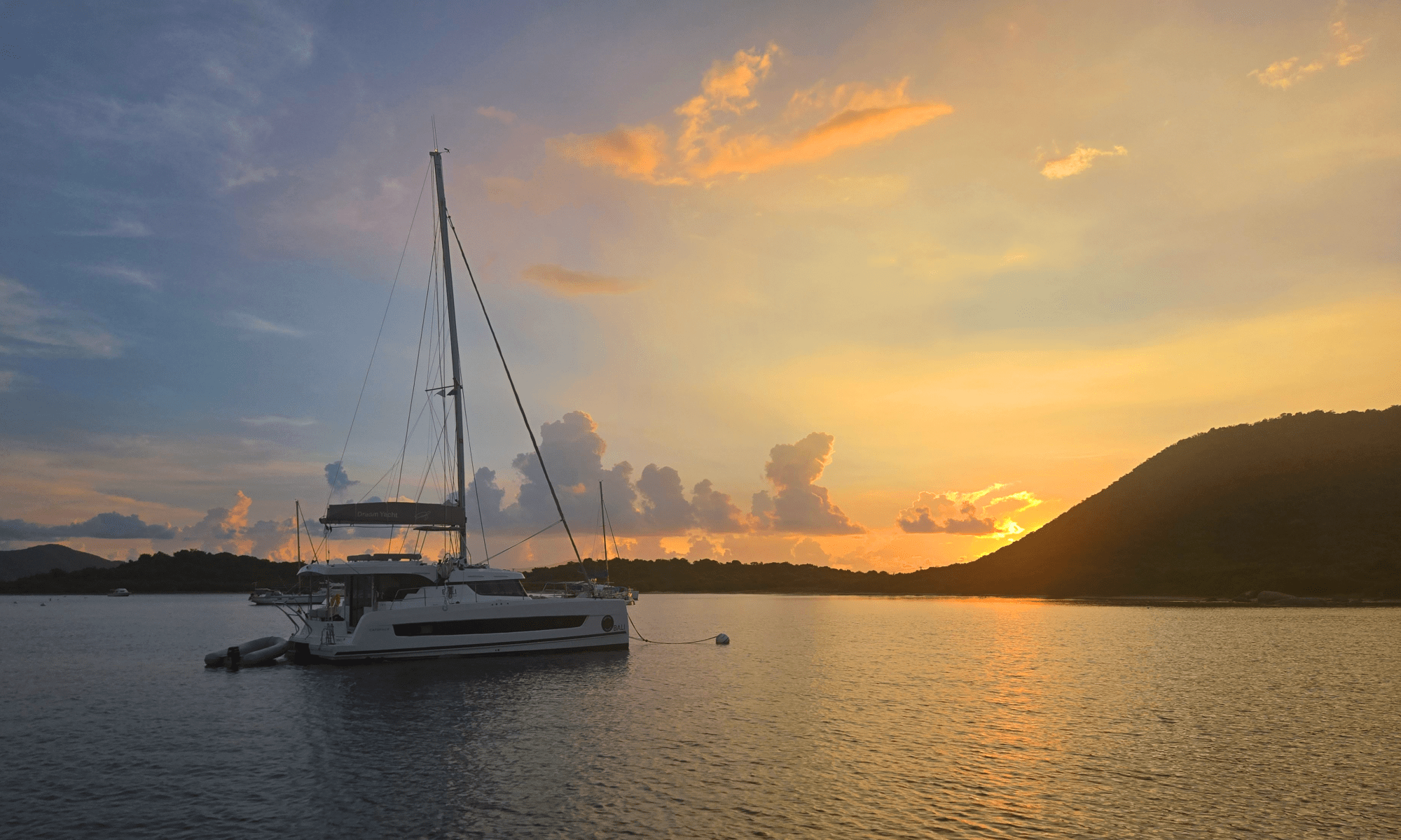 A beautiful golden sunset with a catamaran in the foreground