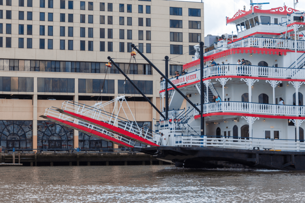 A ferry boat with people on deck, embarking on a river trip