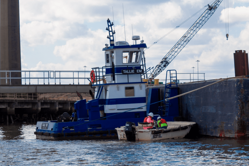 A tugboat and a work boat with crew in the Port of Savannah