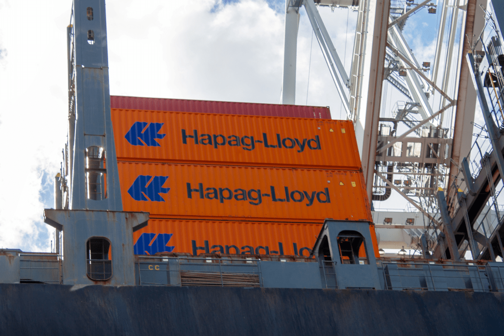 Three Hapag-Lloyd containers stacked on the deck of a container ship