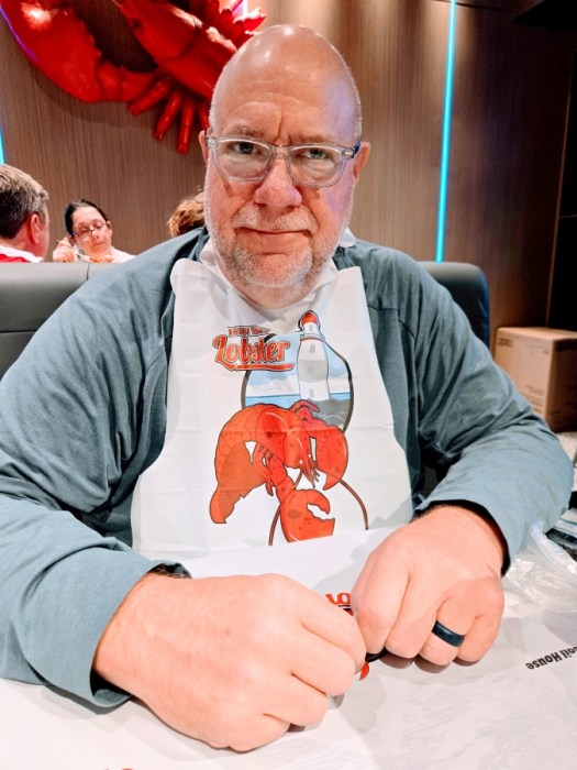 Kent wearing a bib, waiting for his food, at the Hot N Cajun