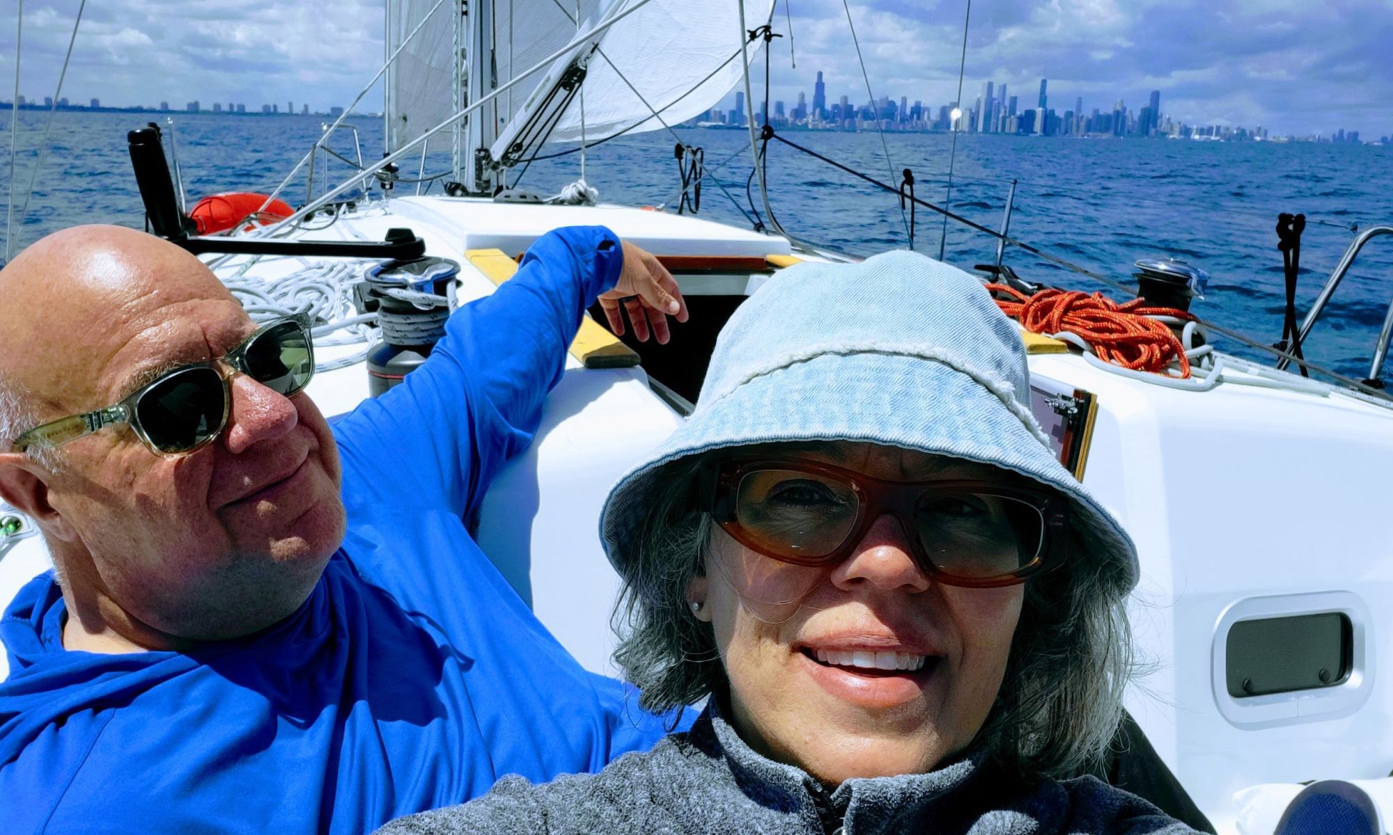 Kent and Becca sitting in the cockpit, smiling, with the lake and chicago in the background.