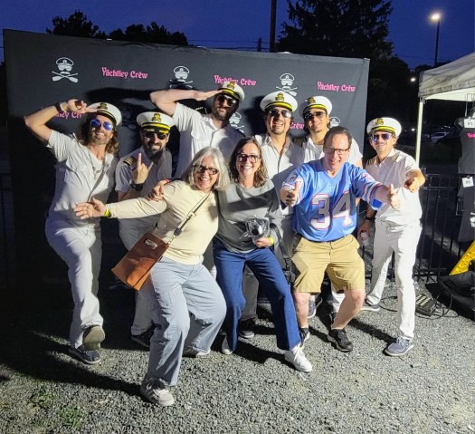 Becca and siblings posing with the band members of Yachtley Crew.