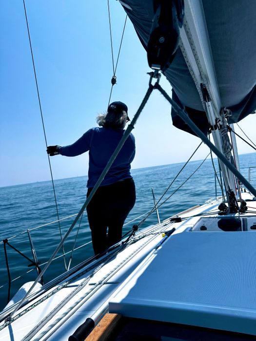 Becca standing on the deck of Red Sky on the waters of Lake Michigan.