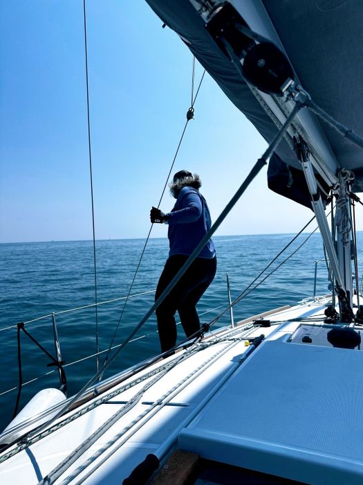 Becca standing on the deck of Red Sky on the waters of Lake Michigan.