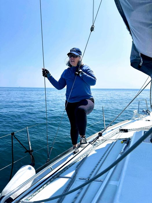 Becca standing on the deck of Red Sky on the waters of Lake Michigan.