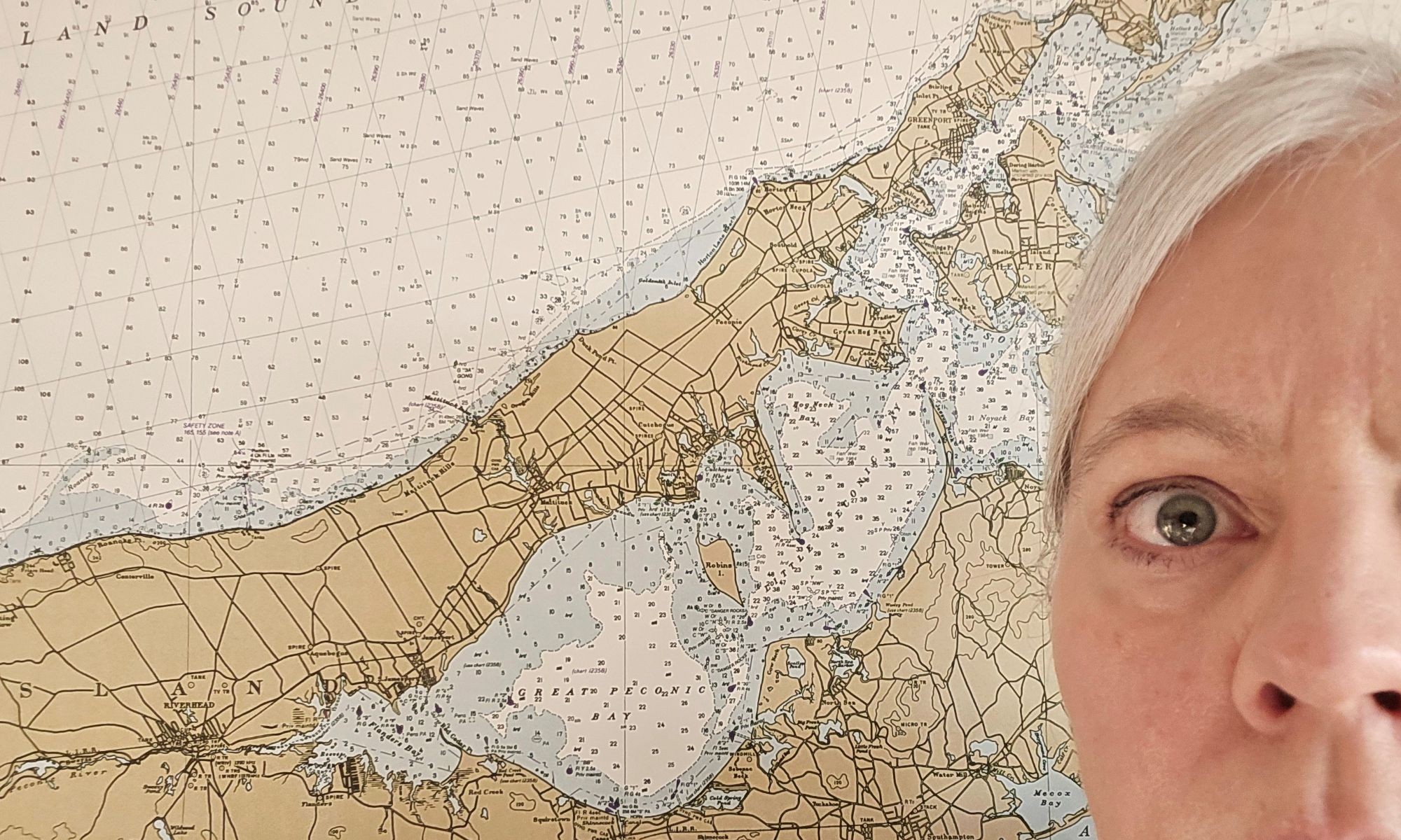 Becca looking stressed standing in front of a nautical chart.