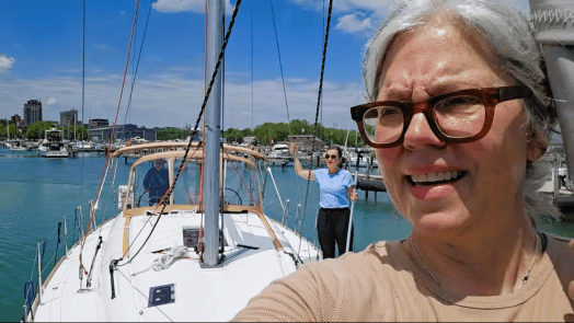 A Becca selfie at the bow of Our Lady, looking back at Maria on deck and Kent at the helm.